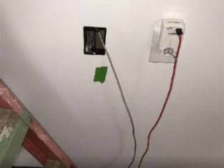 In a room, there is a light switch and electrical wire