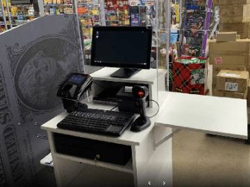 A computer and cash register in a store, facilitating transactions and managing sales efficiently